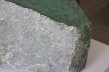 Close-up of a nephrite jade from Quebec. Green stone background and jade. Raw and polished jade. Geology science and mineral from Quebec.   © Martine