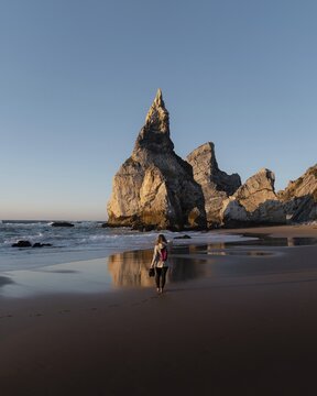Marked rocks at Praia da Ursa beach with person, Ulgueira, Portugal