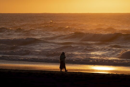 Person walking along the sea, Praia da Adraga, Almocageme, Portugal