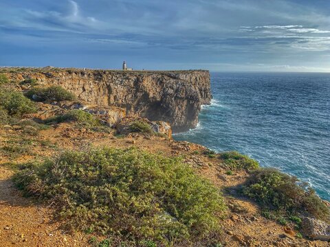 Dramatic coastal cliffs and lighthouse at Ponta da Atalaia near Sagres, Portugal