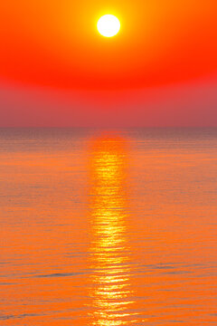 sunrise at the black sea. sun above horizon. reflection on the calm water. nature background in warm orange light