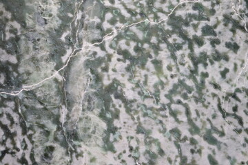 Close-up of a nephrite jade from Quebec. Green stone background and jade. Raw and polished jade. Geology science and mineral from Quebec. © Martine