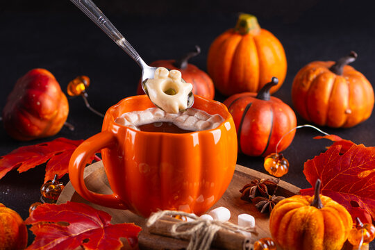 Cozy Autumn Beverage with Pumpkin Mug Marshmallows Cinnamon Sticks and Seasonal Decorations