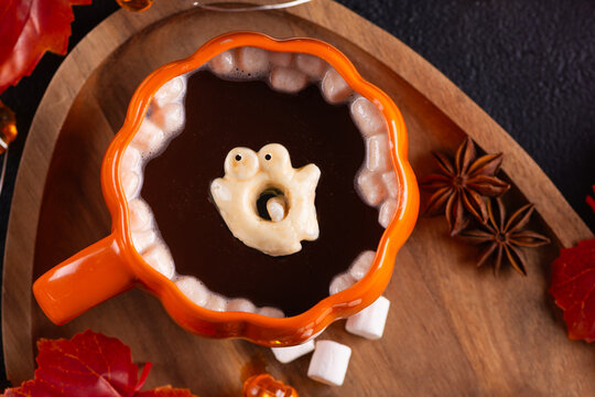 Cozy Halloween Themed Hot Chocolate with Marshmallows and Ghost Decoration on Wooden Tray