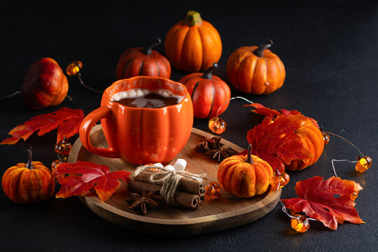 Autumnal warm beverage with pumpkin decorations and cinnamon sticks perfect for fall holidays