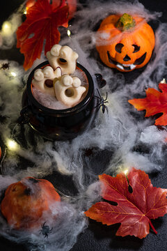 Spooky Halloween treats with pumpkins, spiders, cobwebs, and festive lights creating a festive holiday atmosphere