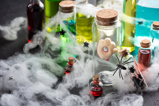 Halloween potions and decorations with spiders and cobwebs on a dark background for holiday celebrations