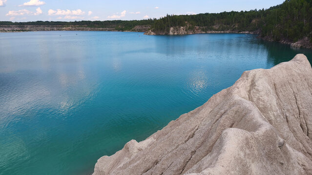 A turquoise lake with white rocky cliffs under a bright summer sky, a natural backdrop with a picturesque landscape, perfect for travel, relaxation and outdoor adventures.