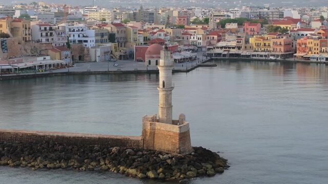  View of Chania with the amazing lighthouse, mosque, venetian shipyards, Crete, Greece.Waves crashing on lighthouse, Beautiful Greece and best scenic places - panorama