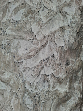 Rough grey plaster stucco texture with swirl patterns and uneven vintage wall finish background