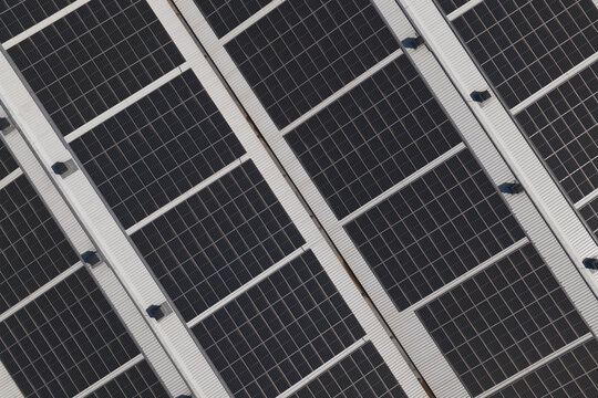 Portugal - 14 August 2026: Aerial view of solar panels installed on a factory rooftop, showcasing decentralized energy production.