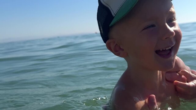 Family playing with son in the sea. 4k