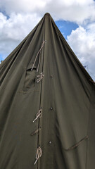 Olive green military pyramidal tent with canvas entrance.  © Inha
