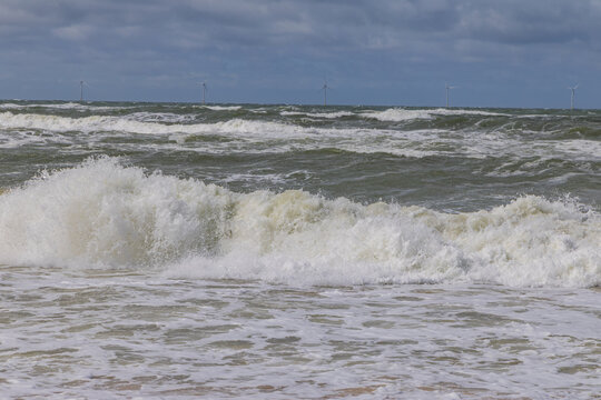 Wild Sea Surf Breaking on a Sandy Beach Under a Stormy Sky
