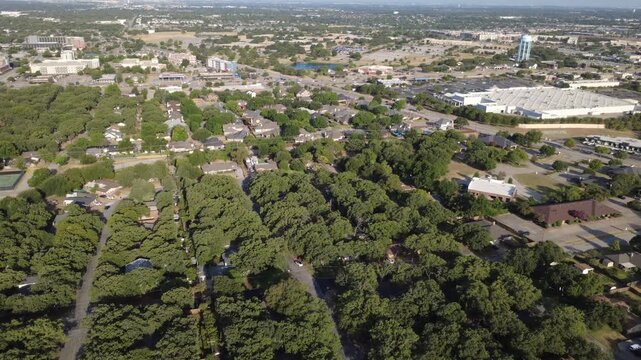 Broad municipal horizons reach toward bustling commercial retail centers along Precinct Line Road. Dense hardwood canopies, single family rooflines, winding streets show DFW sprawl, Hurst, Texas