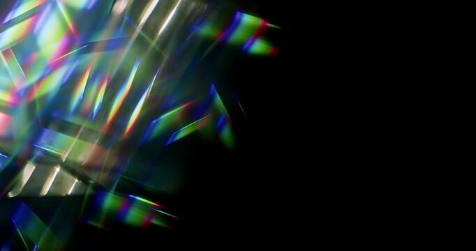 Light ray shining through a prism for angled beams of sparkling shine in brilliant colors. Swirling reflective glass with beaming lights creating visual effect of a brilliant dazzling rainbow. Loop.
