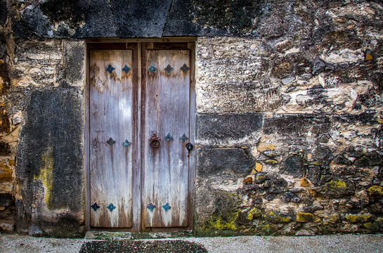 old wooden door with rusty nails stone walls