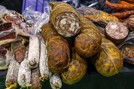 Cured homemade pork sausages and salami pile sold on market
