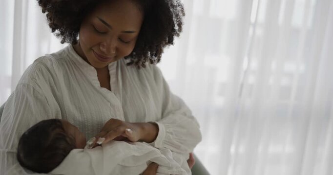 Close up portrait of beautiful young African American mother holding sleep newborn baby in hospital. Healthcare medical love black afro woman lifestyle mother's day, breast concept with copy space.