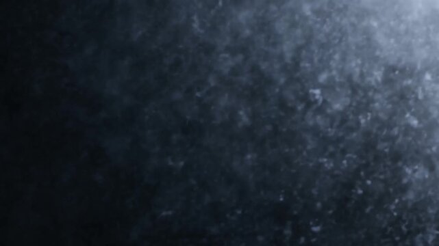Water particles suspended in dark blue fluid with diffuse light and soft texture