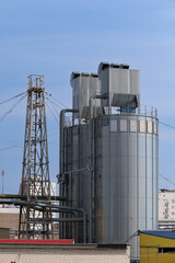 Industrial metal silos and storage tanks with a structural metal tower © BY-_-BY