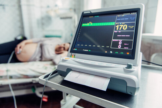 Pregnant woman lying on hospital bed during ctg fetal monitoring examination