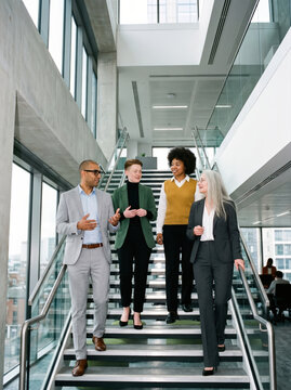 Colleagues walking down an open office staircase