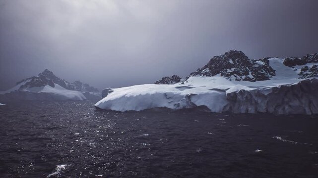 receding icefield revealing exposed rock and dark sea, broad vista under soft light, narrative of retreat and geological reveal with urgent climate undertone