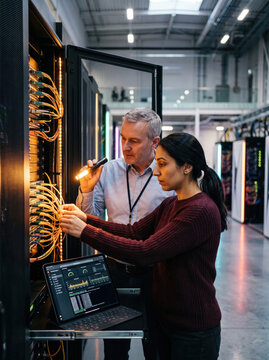 Colleagues troubleshoot network rack in data center