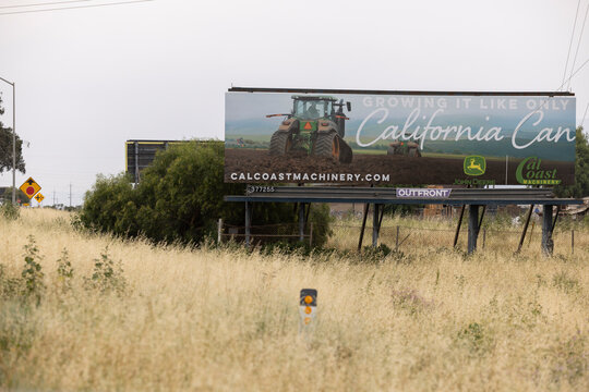 Chualar, California, USA - March 31, 2026: A billboard displays new John Deere agricultural tractor machinery.