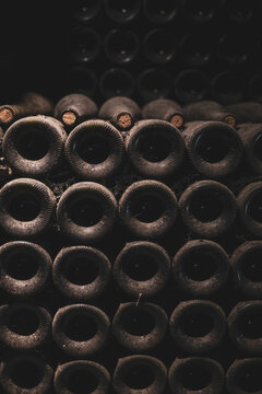 Rows of aged wine bottles stacked in a Beaune cellar in Burgundy, France, showing the timeless craft of wine preservation.