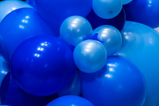 A close-up, full frame shot of multiple shades of glossy blue balloons clustered together, creating a festive backdrop. Shot on location in Brazil,