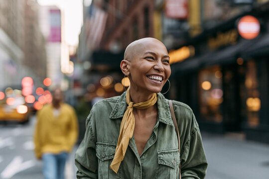 Confident Bald Woman Smiling on Urban City Street