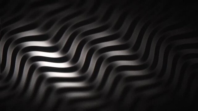 Seamless loop animation: dark cinematic grain with monochrome black and white wavy light ridges in embossed relief, ideal for motion background, titles, branding, and wallpaper.