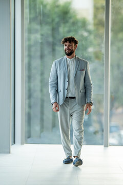 Professional man walking through modern office corridor