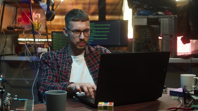 Gamer playing on laptop. Young happy man winning game. Professional gambling programmer infecting system with cyber virus, typing on computer keyboard, breaking password. 