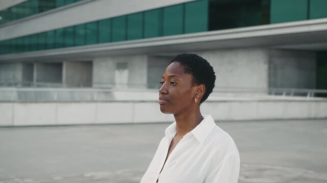 Side profile portrait of a confident Black African American businesswoman outside a modern office building. Professional confidence and corporate success concept.