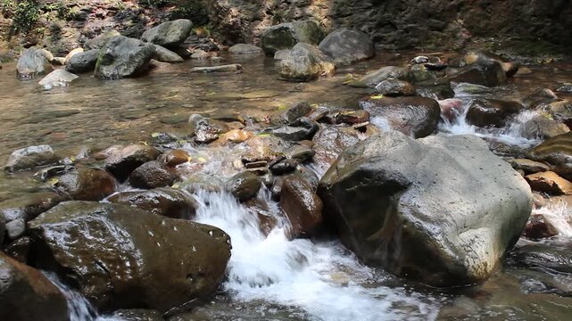Water pushes gently past a cluster of rocks, its rhythm unbroken even as the current shifts direction slightly. A steady, predictable sound like this is often used to ground the body during moments