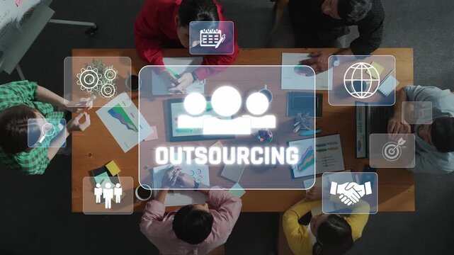 A high-angle view of a team gathered around a table discussing outsourcing solutions, enhanced by icons representing technology, strategy, and collaboration. Raster