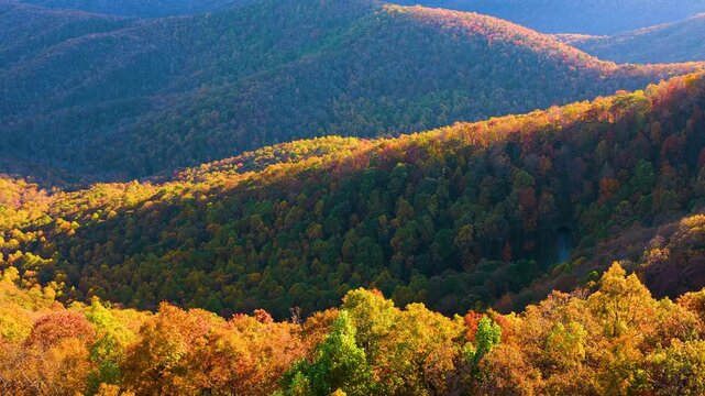 Scenic tunnel on mountain highway in Tennessee Appalachian region. Autumn forest glows with red, orange and golden leaves around Blue Ridge Parkway.