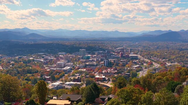 USA travel destination featuring Asheville, North Carolina. Aerial cityscape with downtown buildings framed by brilliant autumn colors in Appalachian Mountains.