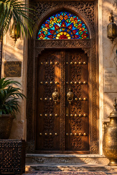 Carved Wooden Door With Glowing Stained Glass Transom Above