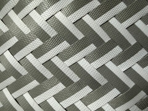 A diagonal criss-cross woven strap or webbing design using light silver-grey and dark charcoal grey material.