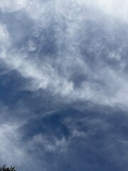 A view of soft, wispy cirrus clouds drifting across a deep blue sky. © Anthony