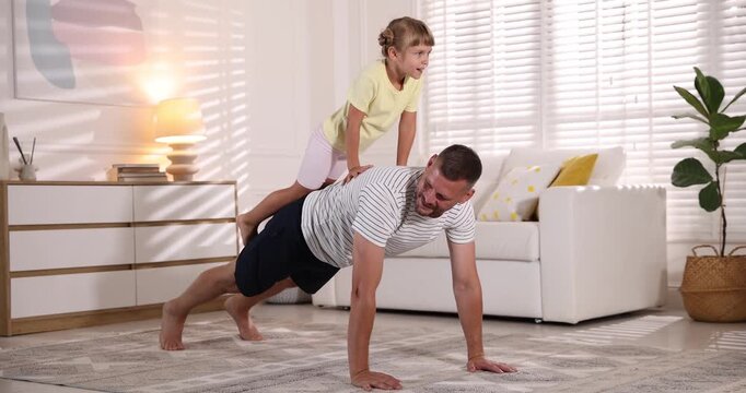 Father and daughter doing morning exercise together at home