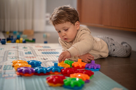 Two-Year-Old Toddler Boy Playing with Colorful Plastic Gear Building Toy
