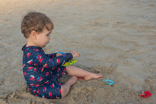 Two-Year-Old Toddler Boy Playing in the Sand on a Beach