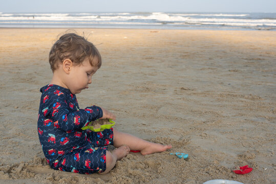 Two-Year-Old Toddler Boy Playing in the Sand on a Beach