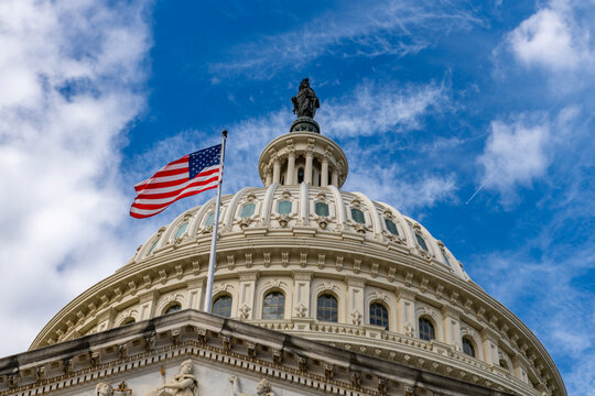 American flag Capitol dome Washington DC clouds. American flag politics governance republic. American flag legislation law voting. American flag historic landmark.