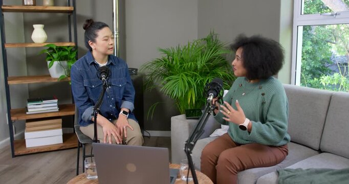 Diverse female hosts right host beginning speaking gesturing left host listening with studio mic